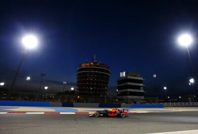 2019年F1巴林大奖赛夜间练习中，红牛RB15驶过灯光下的萨基尔赛道