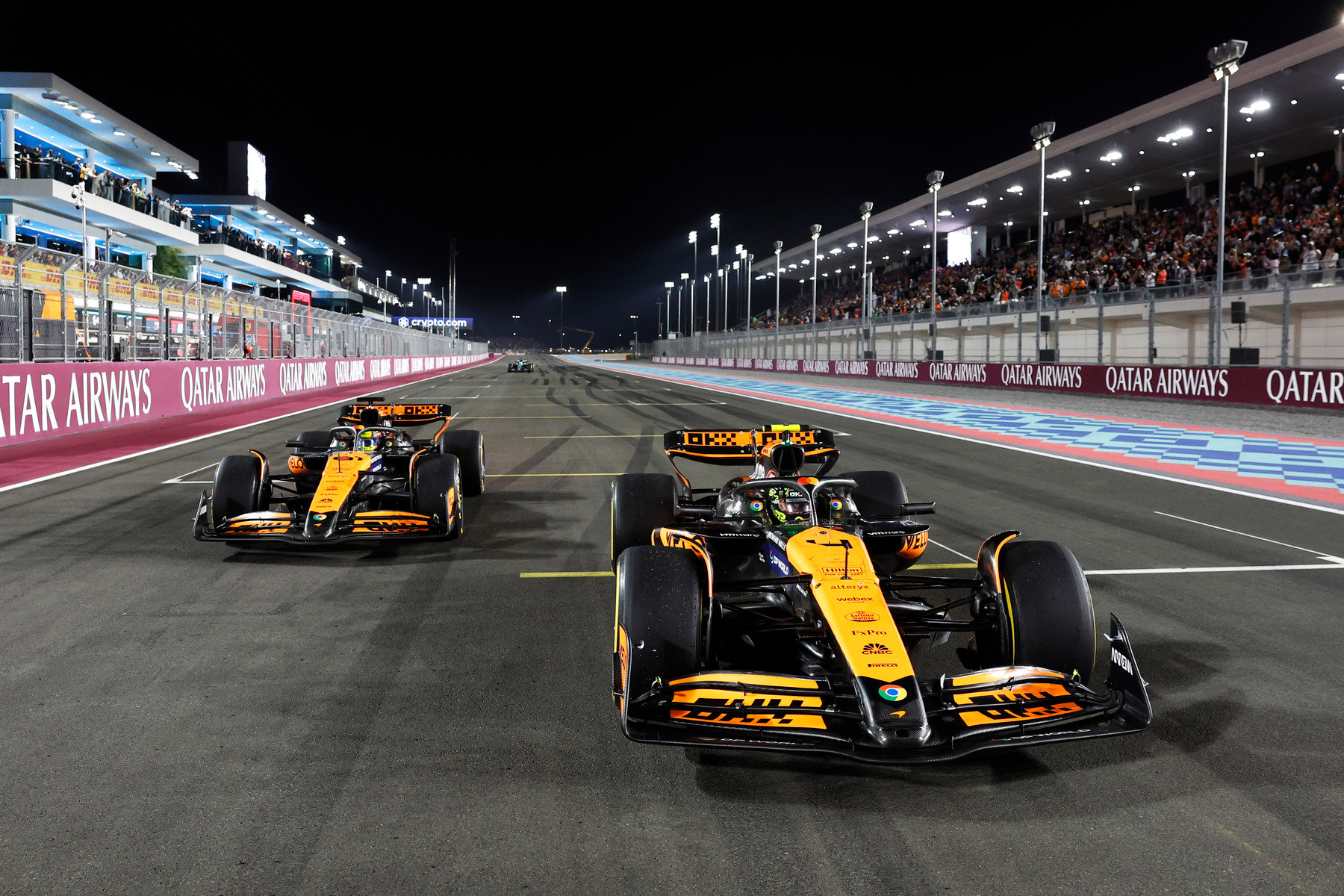 2024年F1卡塔尔大奖赛冲刺赛夜战，迈凯伦两台MCL38赛车在卡塔尔航空背板与满座看台前一前一后竞逐，皮亚斯特里与诺里斯最终包揽前两名