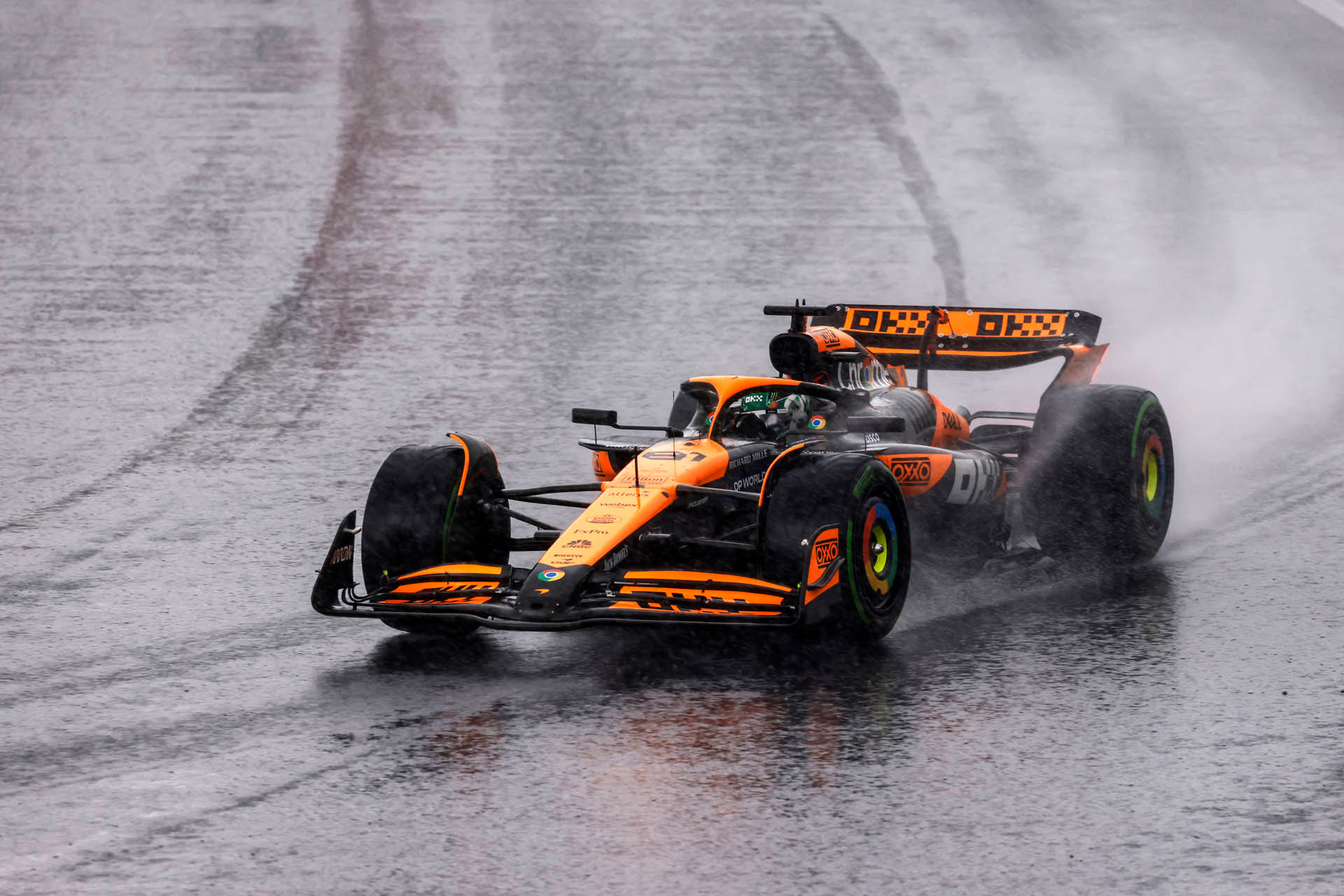 2024年F1圣保罗大奖赛排位赛因暴雨改期至周日上午举行，迈凯伦赛车使用半雨胎在积水中前行激起大量水雾