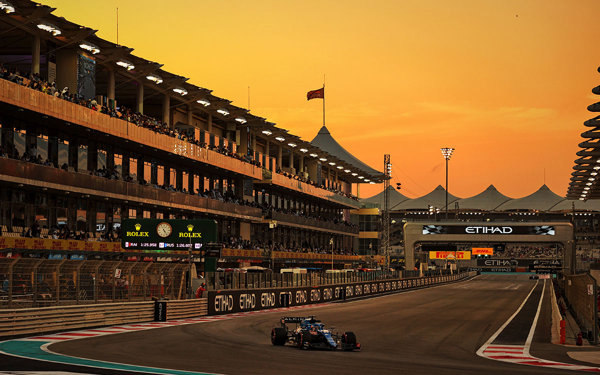 2021年F1阿布扎比大奖赛二练，在暮色中行驶在亚斯码头赛道的阿尔派车手阿隆索