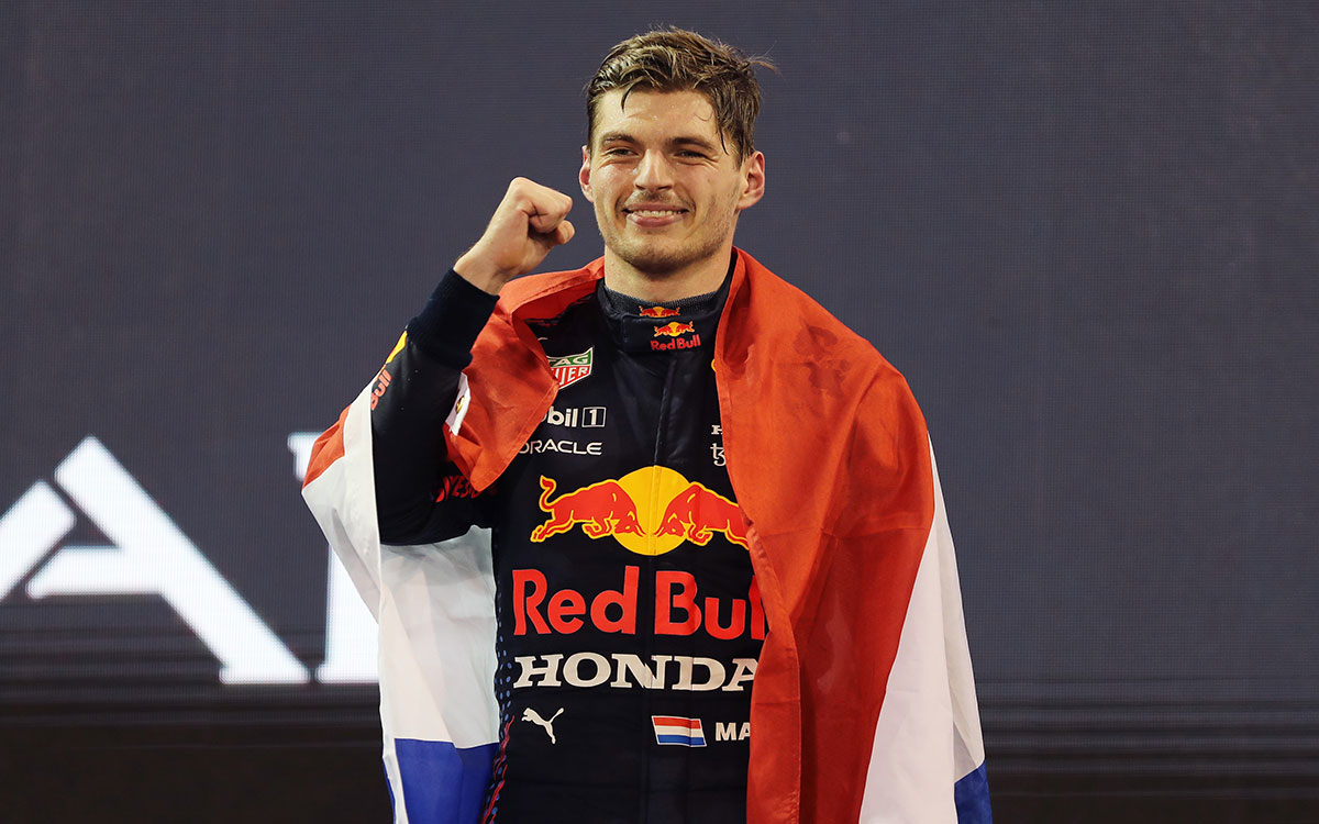 2021年F1阿布扎比大奖赛正赛，身披荷兰国旗在领奖台上握拳庆祝的红牛车手维斯塔潘