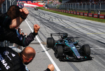 2026年F1奥地利大奖赛正赛，梅赛德斯成员在维修墙向冲线的拉塞尔欢呼