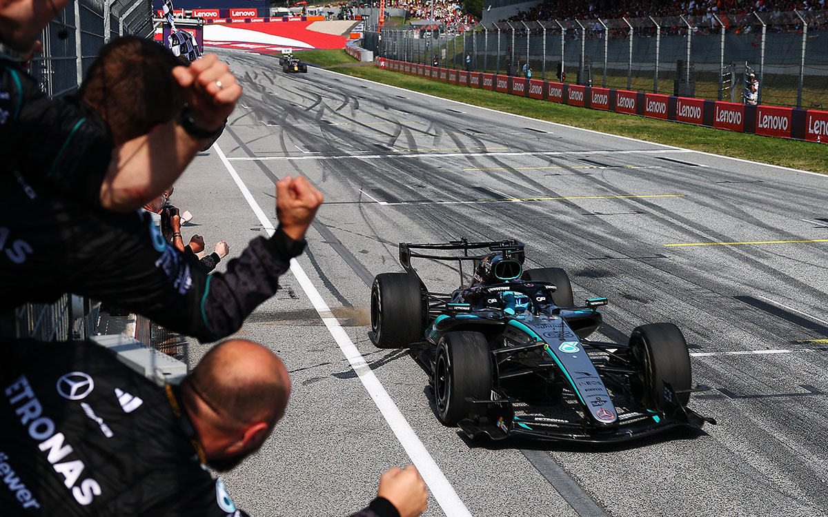 2026年F1奥地利大奖赛正赛，梅赛德斯成员在维修墙向冲线的拉塞尔欢呼