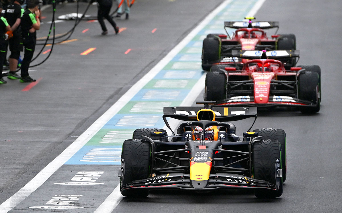 2024年F1比利时大奖赛，维斯塔潘驾驶红牛赛车与法拉利车群在雨中驶过斯帕赛道维修区通道
