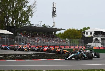 2026年F1加拿大大奖赛冲刺赛发车后，拉塞尔在1号弯挡住后方车群