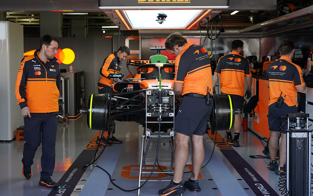 2026年F1日本大奖赛二练,技师们在车库中维护被千斤顶架起的诺里斯赛车