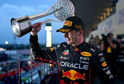 2022年F1日本大奖赛正赛，杆位致胜高举冠军奖杯的维斯塔潘（红牛）