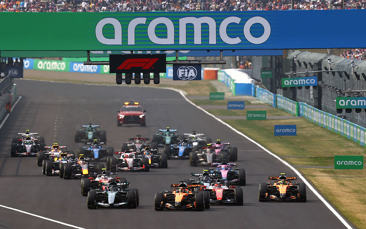 2026年F1日本大奖赛正赛发车后,车群在直道上横向展开激烈争夺,安全车在后方跟进
