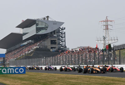 2026年F1日本大奖赛正赛发车后，赛车驶过座无虚席的铃鹿赛道看台