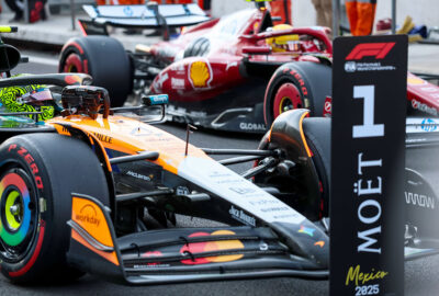 2025年F1墨西哥大奖赛排位赛，杆位诺里斯将车停在P1牌前，第三名汉密尔顿在一旁