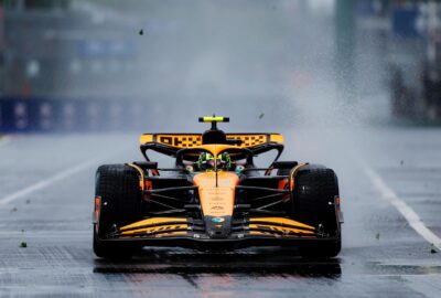 2024年F1加拿大大奖赛二练，迈凯伦赛车在湿滑赛道上高速行驶掀起水雾