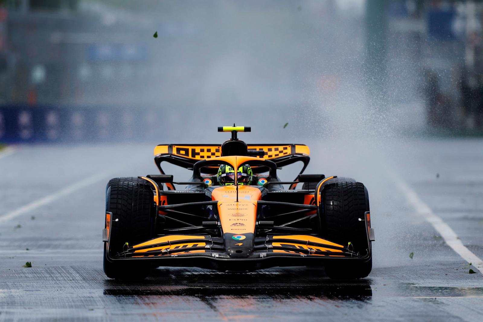 2024年F1加拿大大奖赛二练，迈凯伦赛车在湿滑赛道上高速行驶掀起水雾