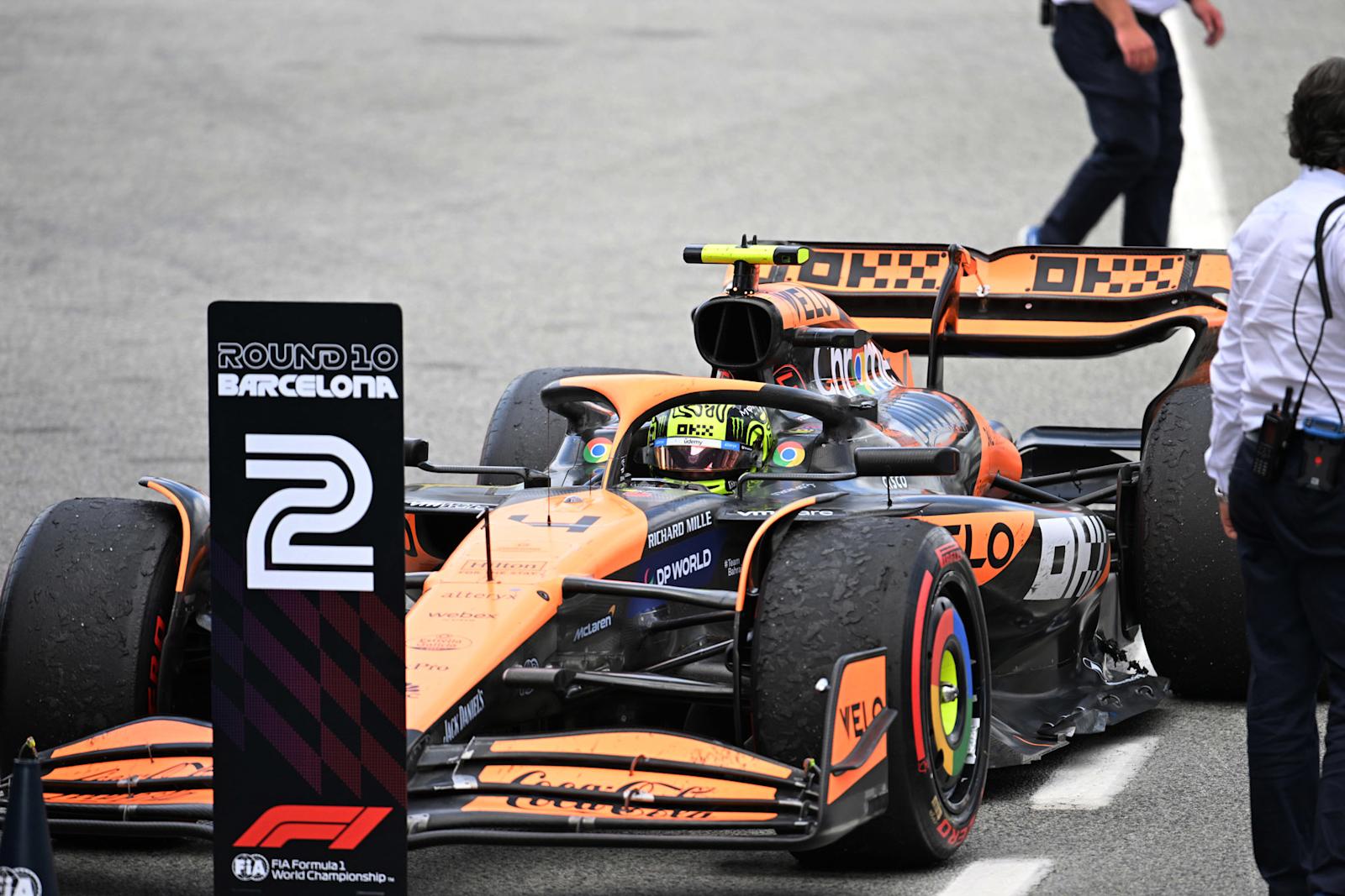 2024年F1西班牙大奖赛正赛,亚军诺里斯驾驶迈凯伦赛车停在赛后停车区,身侧立着第二名指示牌