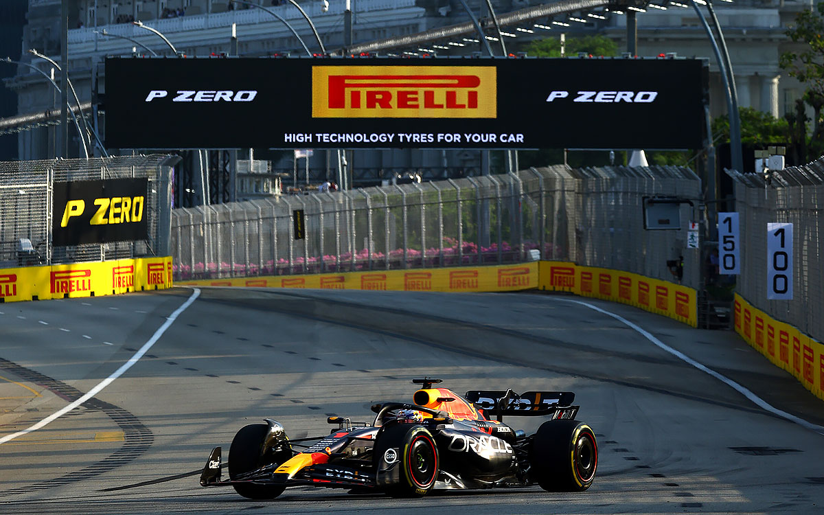 2023年F1新加坡大奖赛三练，维斯塔潘驾驶红牛RB19赛车在黄昏的滨海湾市街赛道通过倍耐力龙门架