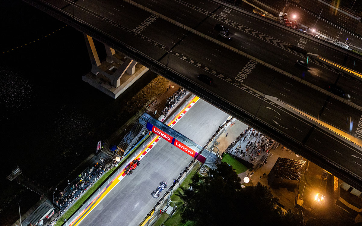 2023年F1新加坡大奖赛排位赛,角田裕毅驾驶红牛二队AT04赛车与塞恩斯的法拉利行驶在滨海湾赛道