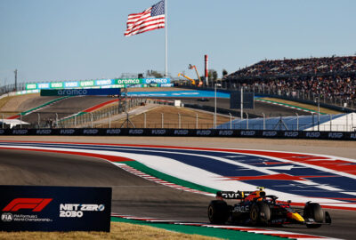 2022年F1美国大奖赛二练，佩雷兹驾驶红牛在星条旗背景下于COTA赛道行驶