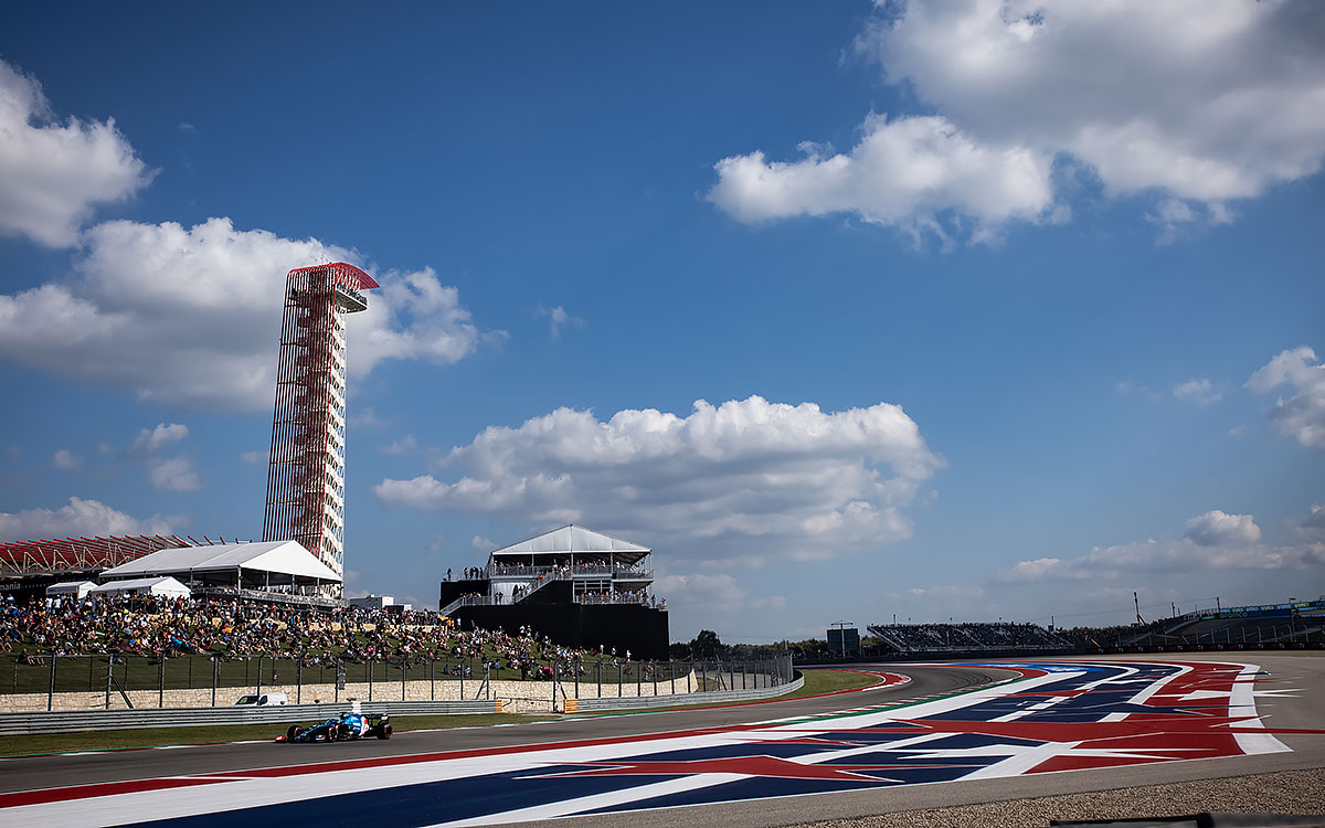 2021年F1美国大奖赛，在美洲赛道（COTA）标志性展望台背景下周圈的阿尔派车手阿隆索