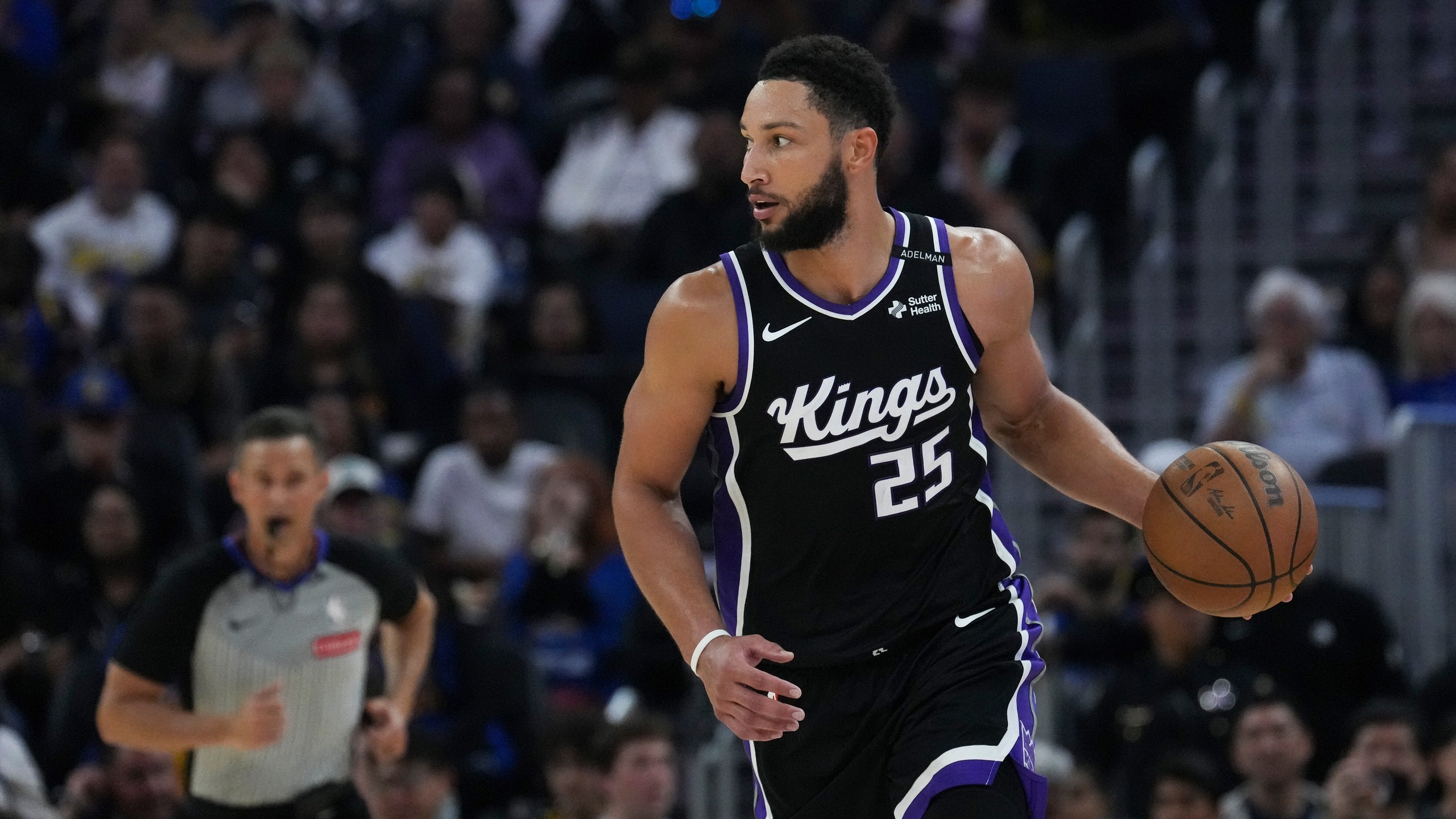 Archive game photo of Ben Simmons handling the ball in Sacramento's No. 25 jersey, not the practice injury