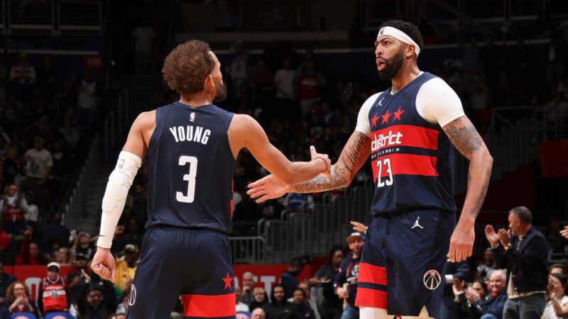 Trae Young and Anthony Davis exchange a high-five in the NBA's photo for the Wizards' season opener.