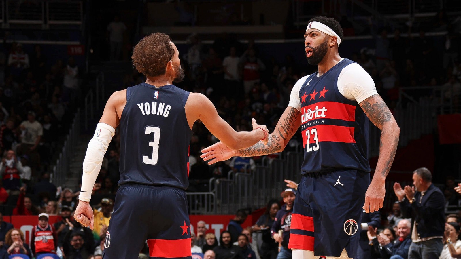 ウィザーズのトレイ・ヤングとアンソニー・デイビスがコートでハイタッチ。本記事のNBA開幕戦の写真。