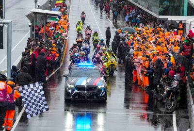 2026年MotoGP澳大利亚站，安全车带领车手通过雨中的维修区通道