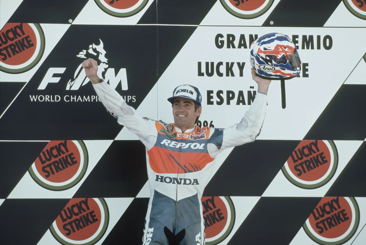 1996年スペインGPの表彰台でヘルメットを掲げるドゥーハン。背景にはEspaña 1996とある。