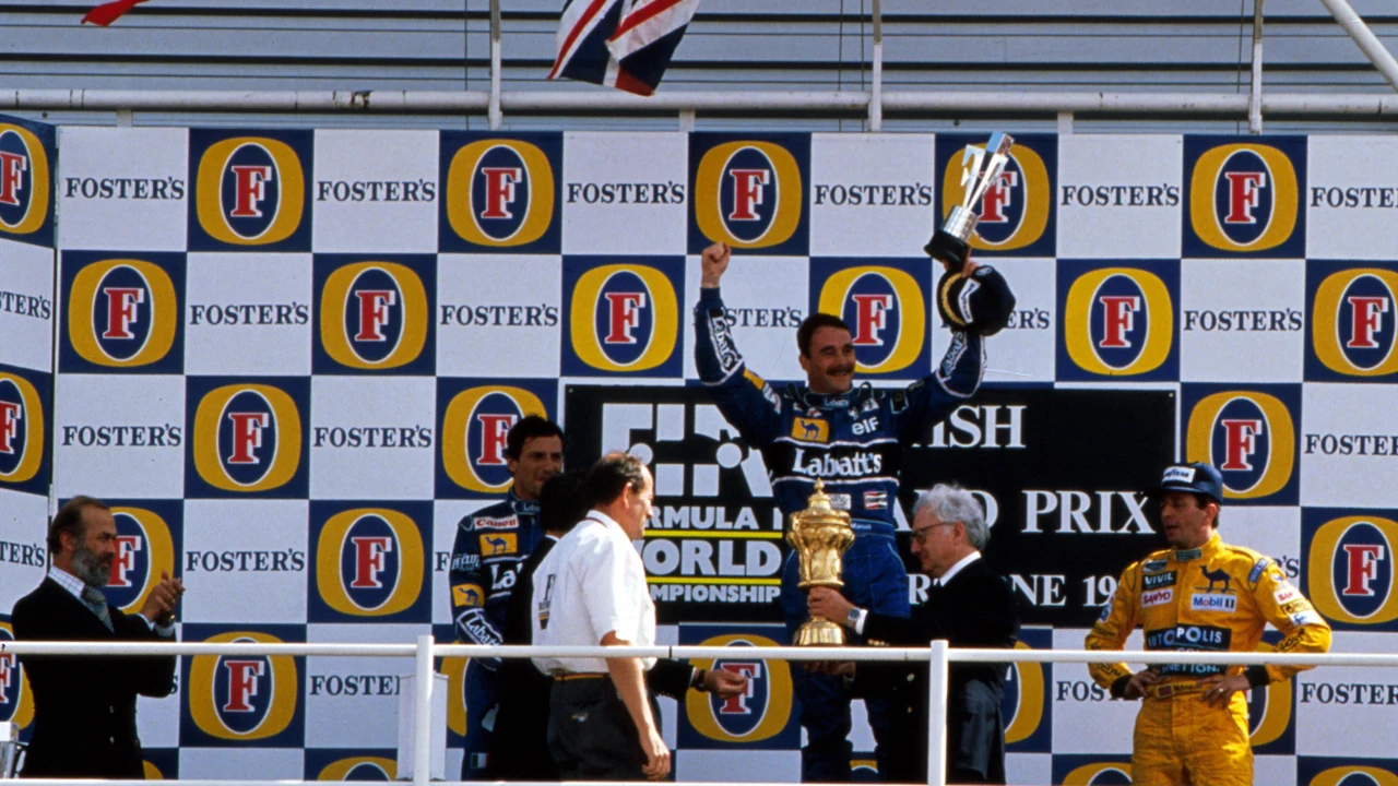 1992年英国GP、シルバーストンの表彰台で優勝トロフィーを掲げるマンセル。