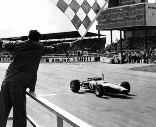 1967年英国GP、5号車ロータス49でチェッカーフラッグを受けるジム・クラーク