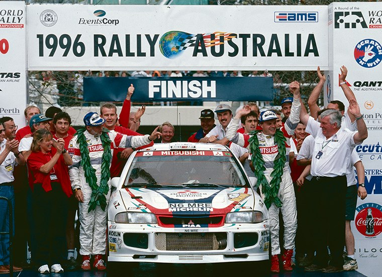 Tommi Mäkinen, his co-driver and the Mitsubishi team celebrate at the finish of the 1996 Rally Australia