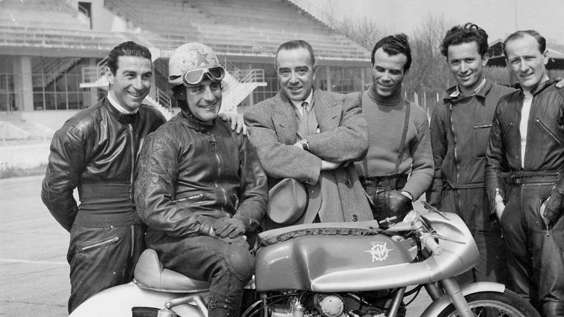 Early MV Agusta riders and staff gathered around a motorcycle